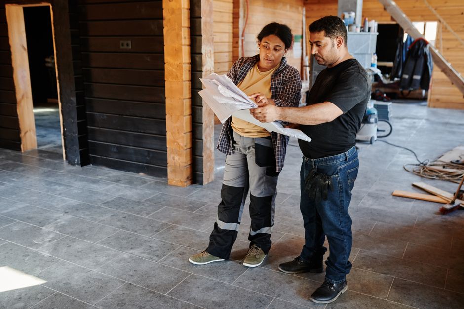 Contractors reviewing architectural blueprints for home remodeling